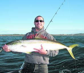 Nathan on Smithys Fishing Charter holding up a ripper yellowtail kingfish he caught in close in 26m of water.